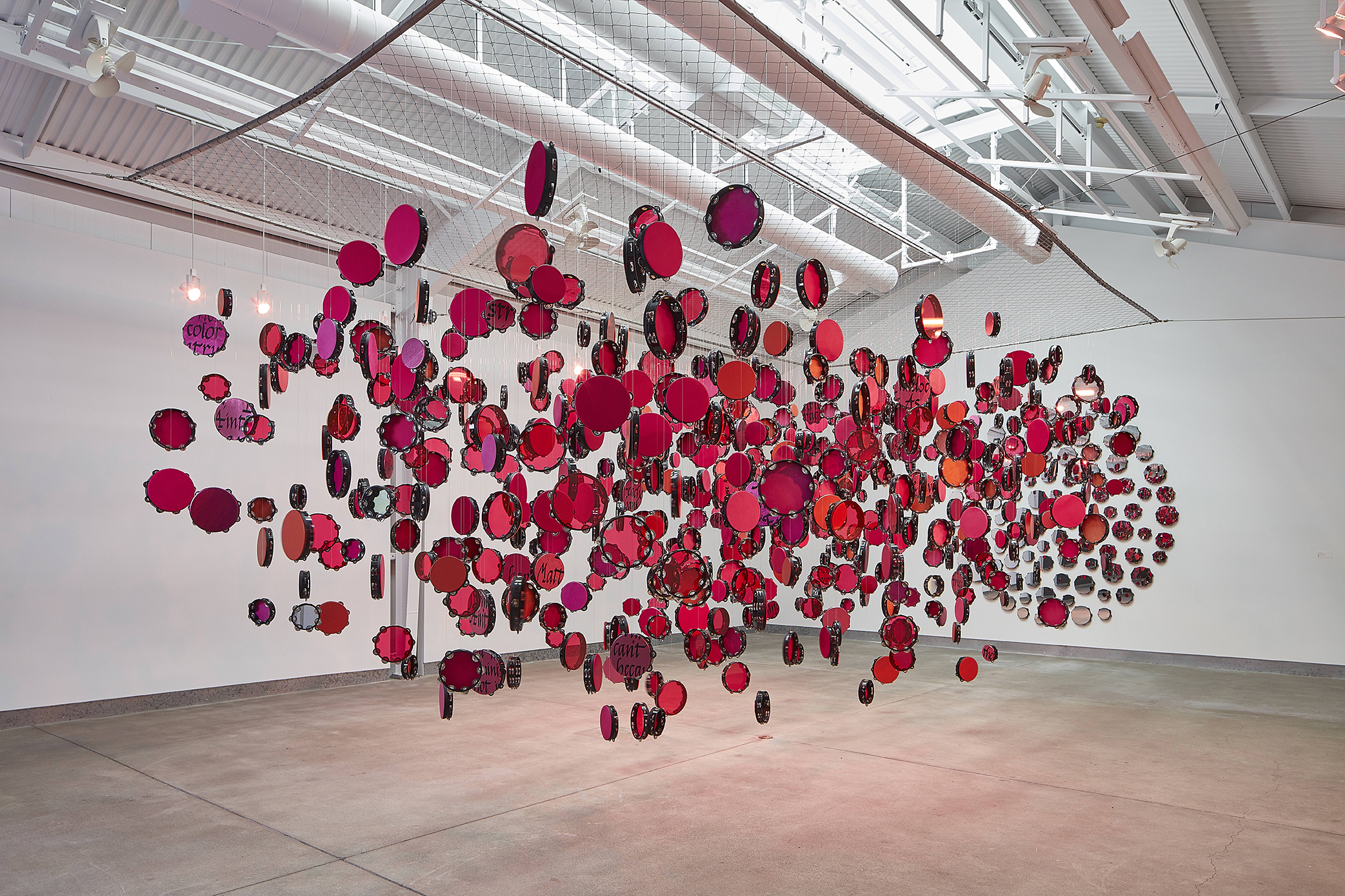 Lava Thomas, Resistance Reverb: Movements 1 & 2, 2018. Tambourines, leather, suede, Plexiglas, mirrored acrylic, acrylic paint, monofilament wire, S-hooks, aluminum grid, steel, fans, and lights. Approx. 102 × 156 × 312 in.